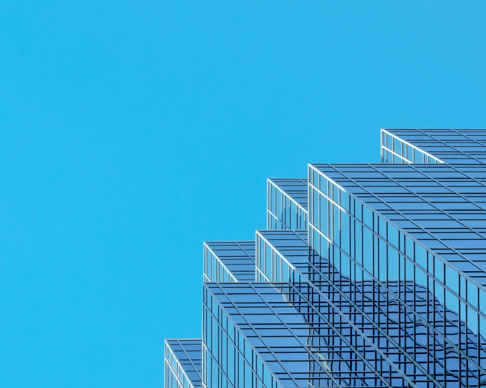 A modern glass skyscraper against a clear sky